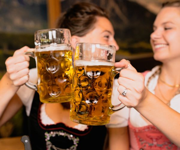 An image of two women toasting beers at an Oktoberfest event.